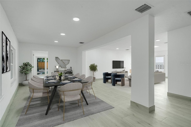 dining area with light wood finished floors, visible vents, and recessed lighting