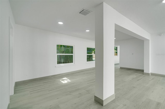 empty room featuring light wood-style flooring, visible vents, baseboards, and recessed lighting