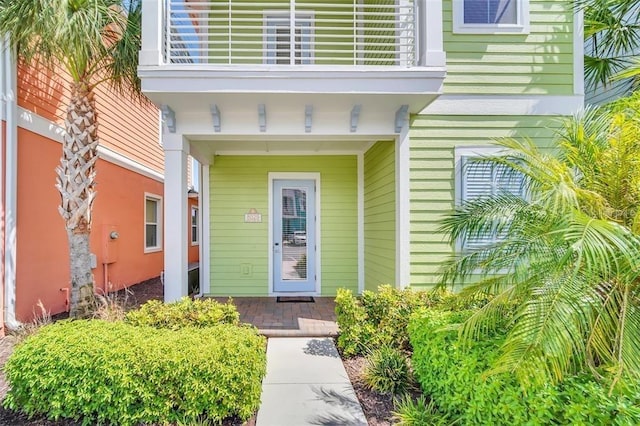 doorway to property with a balcony and a porch