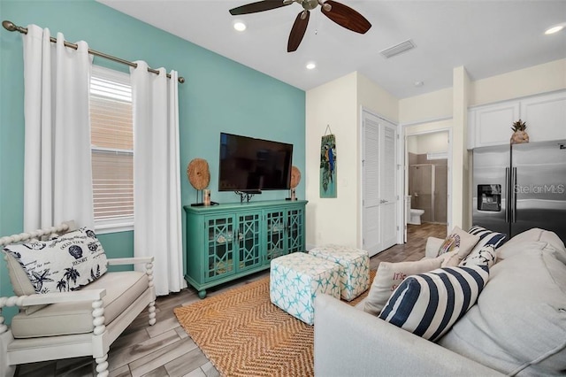 living area featuring ceiling fan, wood finished floors, visible vents, and recessed lighting