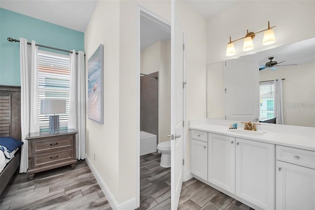 bathroom featuring baseboards, toilet, ceiling fan, wood tiled floor, and vanity