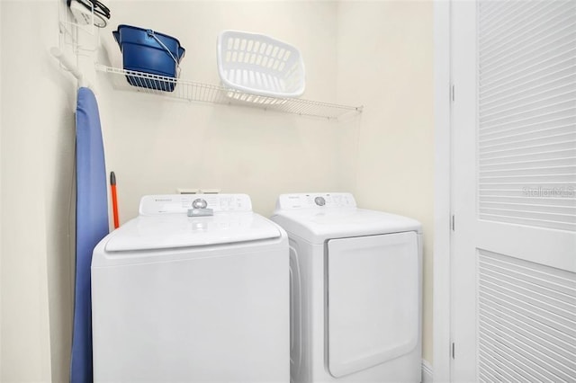 clothes washing area with washing machine and dryer and laundry area