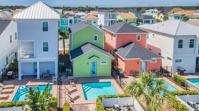 rear view of property with a patio area, a residential view, fence, and a community pool