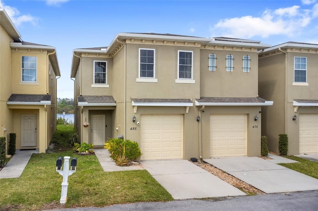 view of property with a garage, concrete driveway, and stucco siding