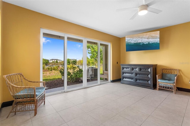 sitting room with ceiling fan, tile patterned flooring, and baseboards