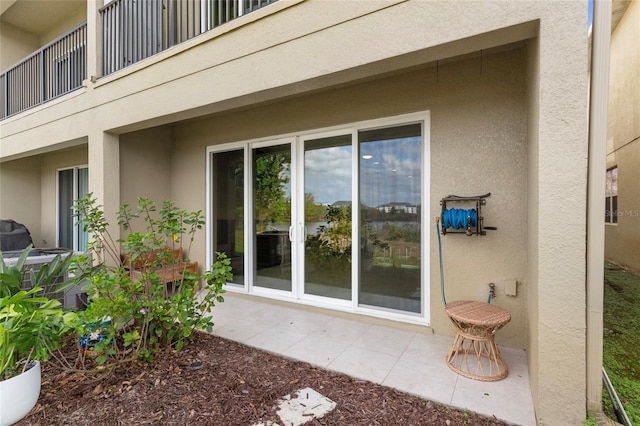 view of property exterior featuring a patio, a balcony, and stucco siding