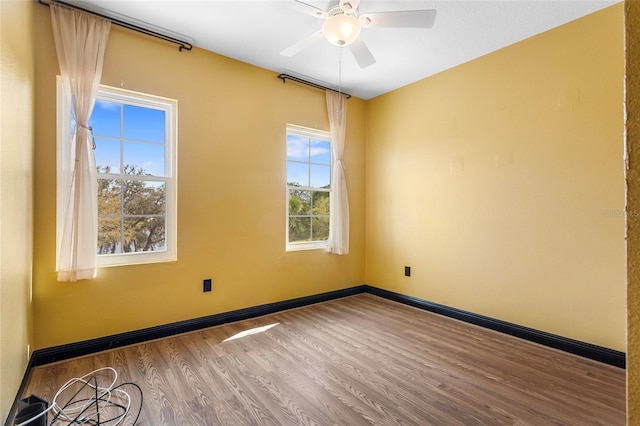 unfurnished room with a ceiling fan, baseboards, and wood finished floors