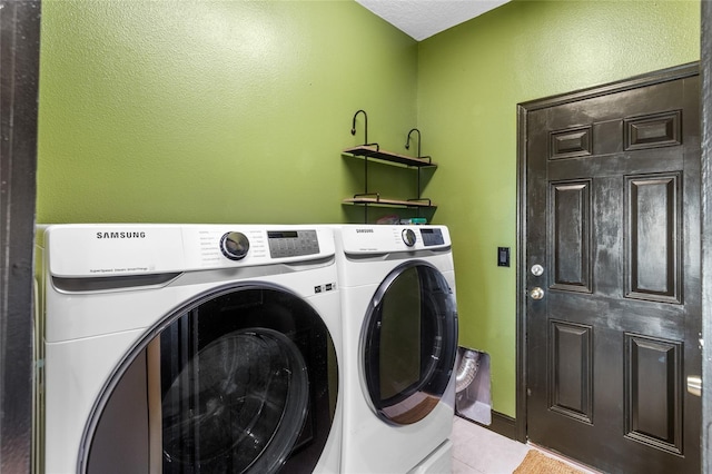 washroom featuring laundry area, separate washer and dryer, and tile patterned floors