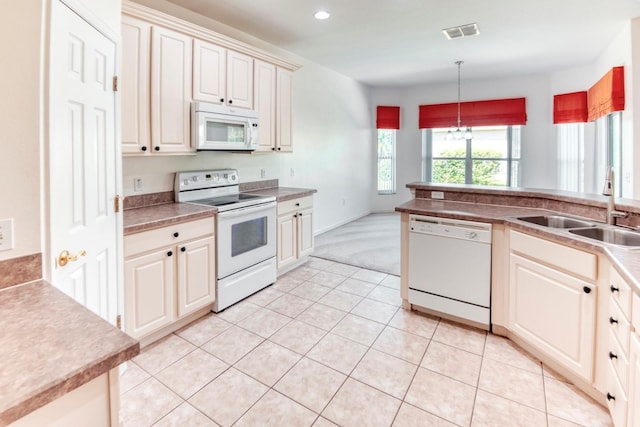 153 Ventana Dr, Poinciana, FL 34759 - kitchen with white appliances, light tile patterned floors, visible vents, a sink, and decorative light fixtures