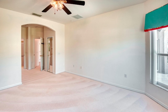 153 Ventana Dr, Poinciana, FL 34759 - spare room featuring light colored carpet, arched walkways, visible vents, and ceiling fan