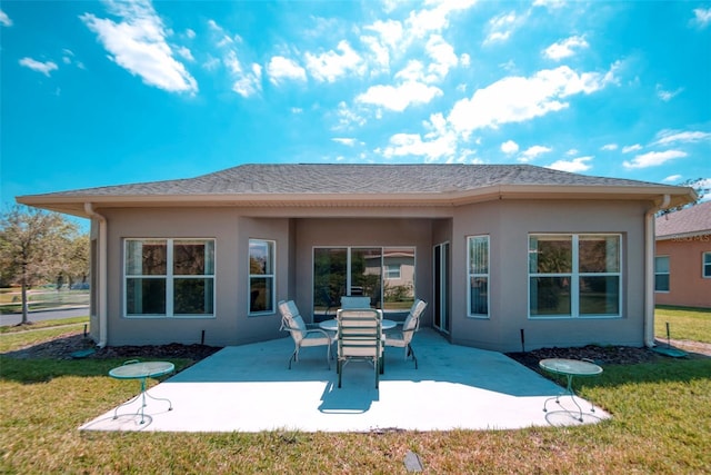 153 Ventana Dr, Poinciana, FL 34759 - back of property with a yard, a shingled roof, stucco siding, and a patio area