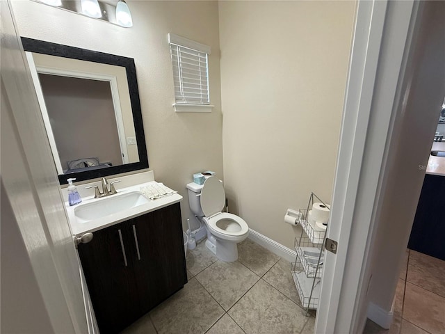 half bath featuring baseboards, toilet, vanity, and tile patterned flooring