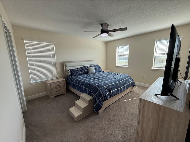 bedroom featuring ceiling fan, carpet, baseboards, and a textured ceiling