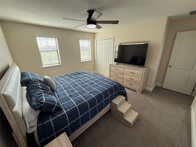 bedroom with a ceiling fan, a textured ceiling, a closet, baseboards, and light colored carpet