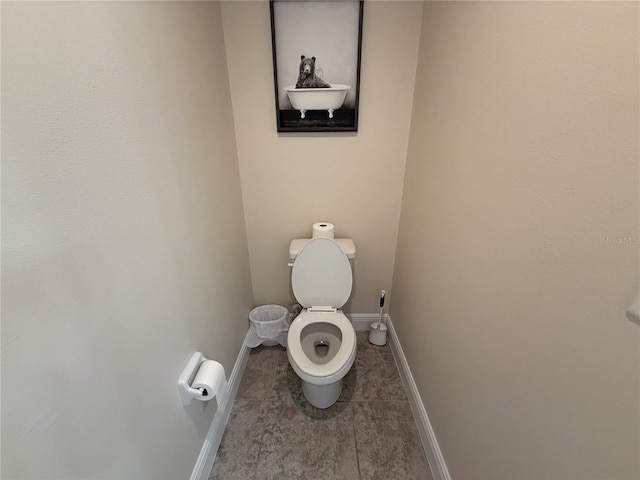 bathroom with tile patterned floors, toilet, and baseboards