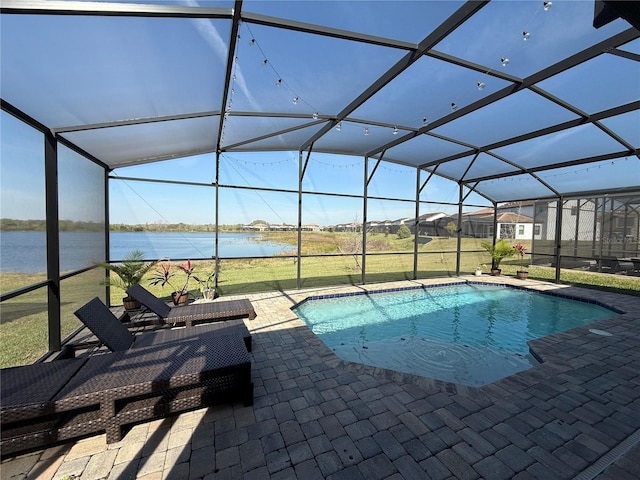 pool featuring glass enclosure, a patio, and a water view