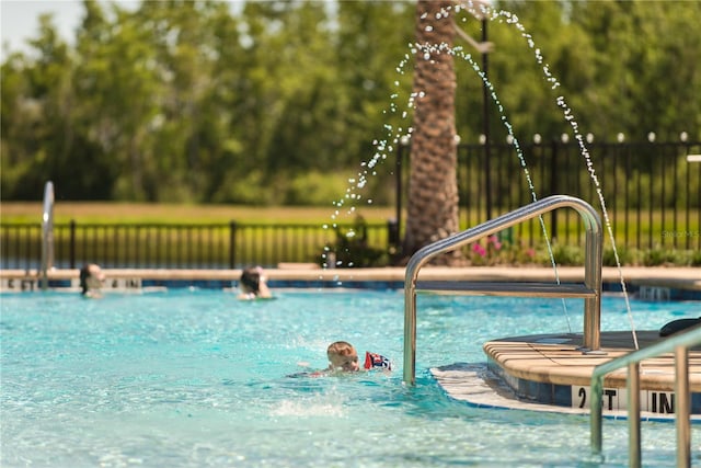 view of swimming pool featuring fence