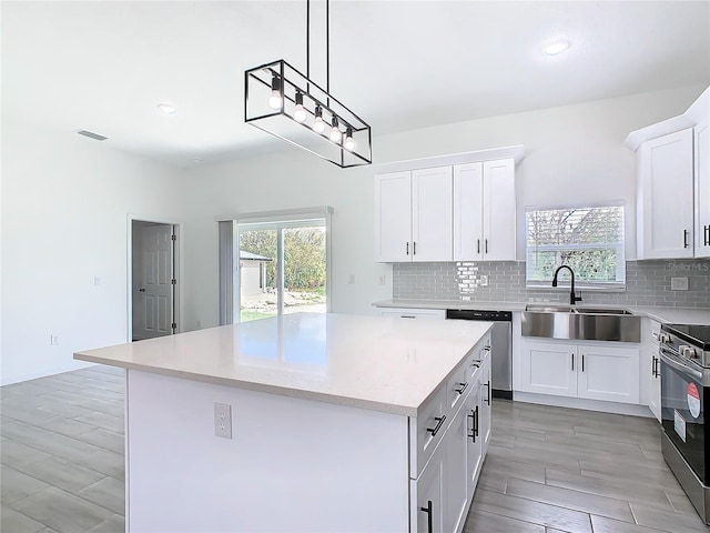 kitchen with appliances with stainless steel finishes, a center island, a sink, and tasteful backsplash