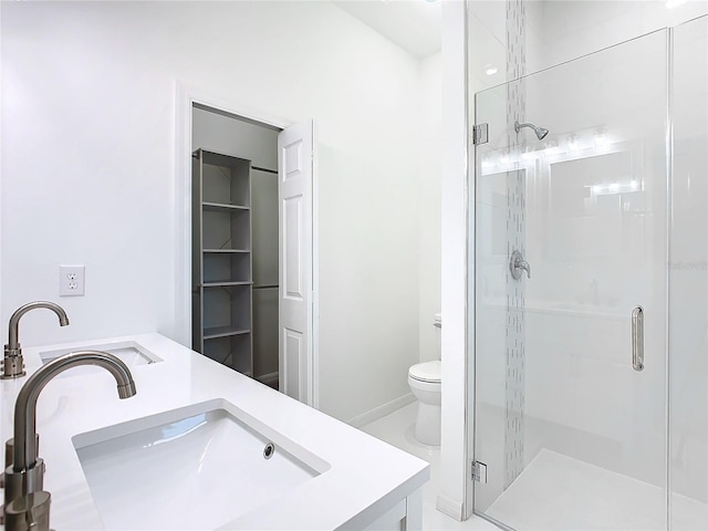 bathroom featuring toilet, a shower stall, and vanity