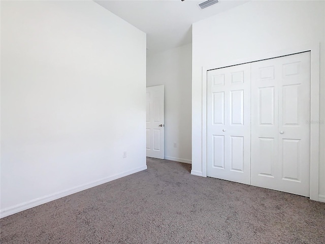 unfurnished bedroom with carpet, a closet, visible vents, and baseboards