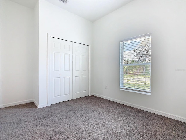 unfurnished bedroom with carpet, baseboards, and a closet