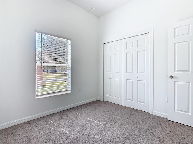 unfurnished bedroom featuring carpet floors, a closet, and baseboards