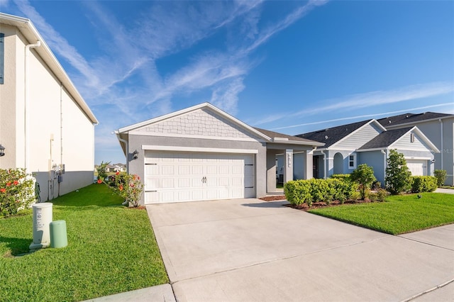 view of front facade with a front yard, an attached garage, and stucco siding