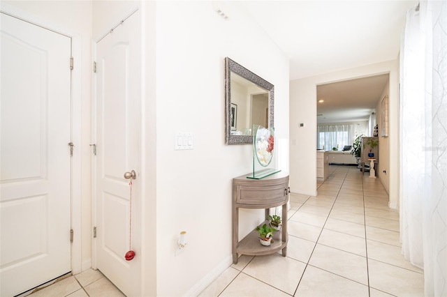 corridor with light tile patterned floors and baseboards