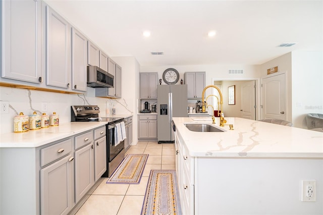 kitchen featuring appliances with stainless steel finishes, gray cabinets, visible vents, and a sink