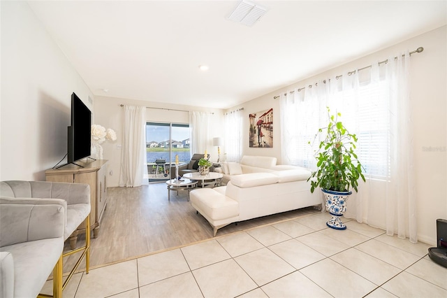 living room featuring light tile patterned floors and visible vents