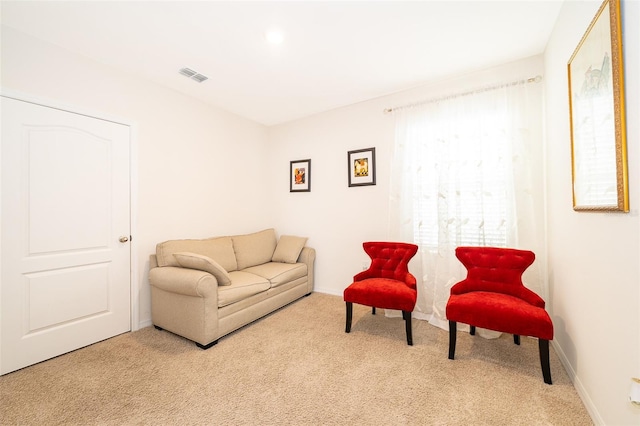 carpeted living area with visible vents and baseboards