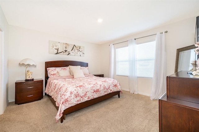 bedroom with light carpet and baseboards