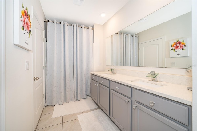 full bath featuring double vanity, curtained shower, tile patterned flooring, and a sink