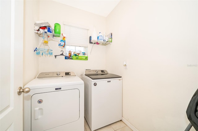 laundry area featuring laundry area, separate washer and dryer, light tile patterned flooring, and baseboards