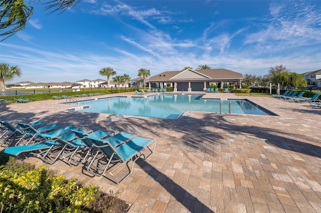 pool with a patio area and fence