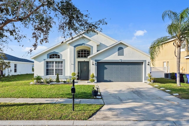 view of front of home featuring a front lawn, an attached garage, driveway, and stucco siding