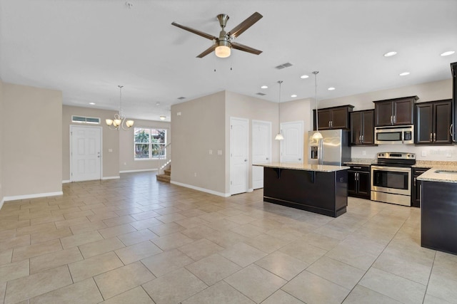 kitchen featuring ceiling fan with notable chandelier, visible vents, open floor plan, appliances with stainless steel finishes, and a center island