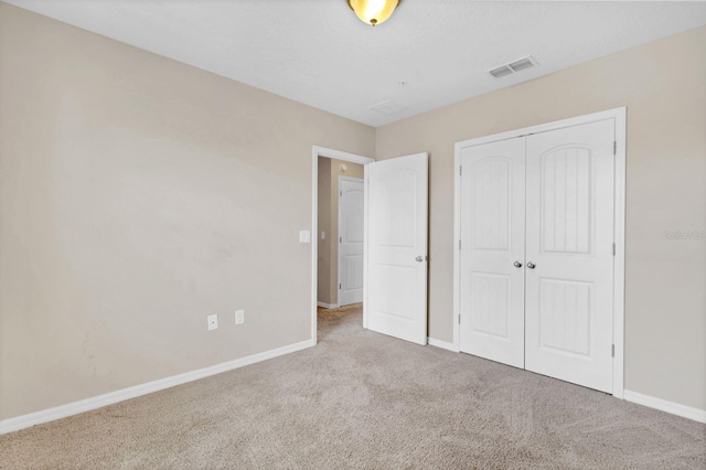 unfurnished bedroom featuring carpet flooring, visible vents, and baseboards