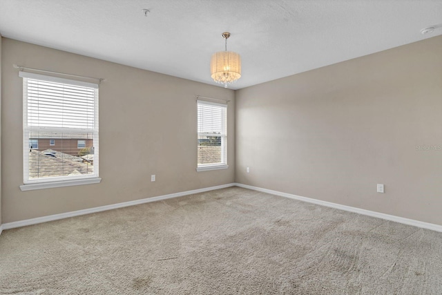 carpeted empty room featuring baseboards