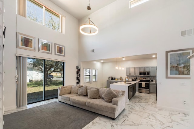 living area featuring marble finish floor, baseboards, and visible vents