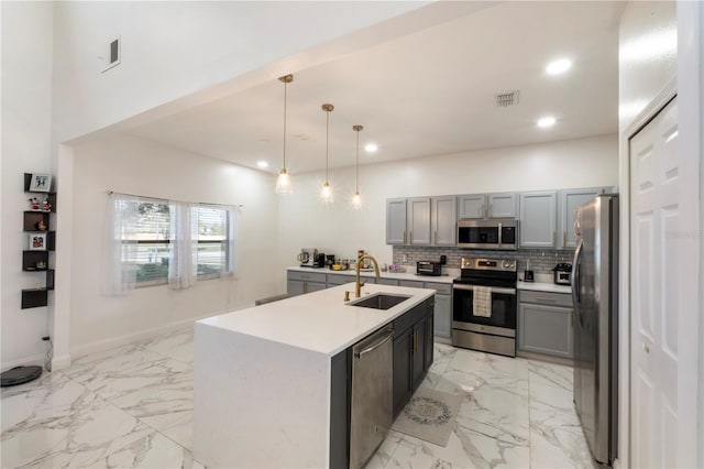 kitchen with decorative backsplash, appliances with stainless steel finishes, marble finish floor, gray cabinets, and a sink