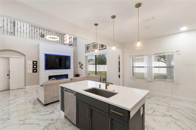 kitchen with dishwasher, marble finish floor, a sink, and a wealth of natural light