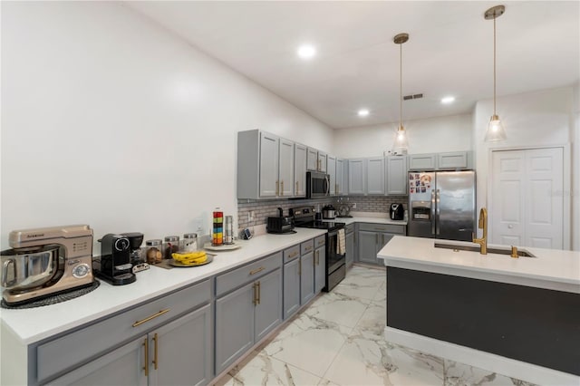 kitchen featuring a sink, marble finish floor, appliances with stainless steel finishes, gray cabinets, and tasteful backsplash