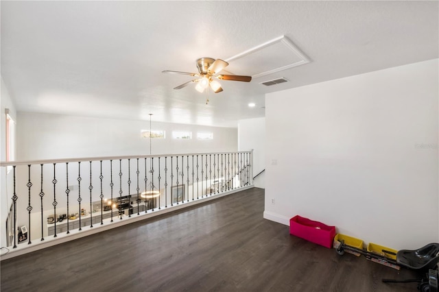 spare room with baseboards, wood finished floors, visible vents, and a ceiling fan