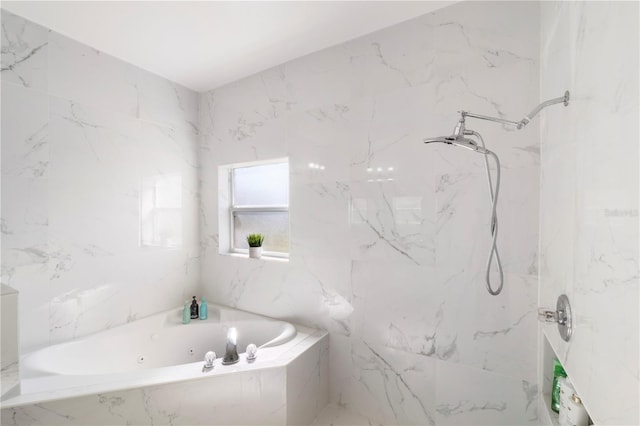 bathroom featuring a jetted tub, a marble finish shower, and stone wall