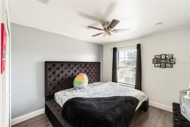 bedroom featuring visible vents, dark wood-type flooring, a ceiling fan, and baseboards