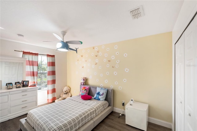 bedroom with wood finished floors, visible vents, baseboards, a closet, and wallpapered walls