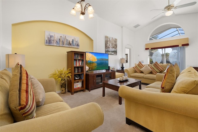 living area with ceiling fan with notable chandelier, high vaulted ceiling, visible vents, and light colored carpet