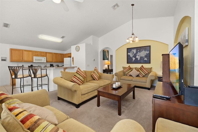 living area with arched walkways, vaulted ceiling, light carpet, and visible vents