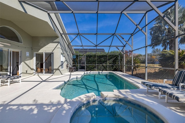 view of pool featuring a patio area, a lanai, and a pool with connected hot tub